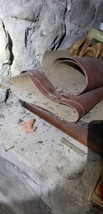 Rat droppings and nest in old carpet in crawlspace found during inspection for rodent control and exclusion